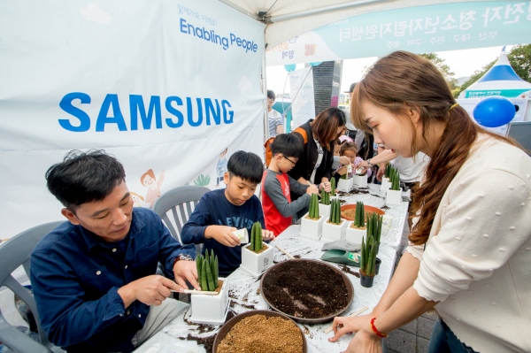 6일 부산에서 열린 '세상모든가족함께 바다 나들이' 행사에 참여한 시민들이 삼성전자 청소년자립지원 사업 소개 부스에서 화분만들기 체험을 즐기고 있다.